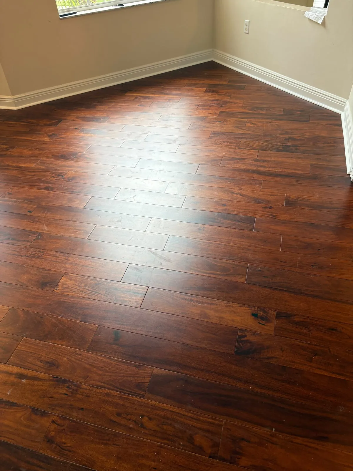 Dark acacia hardwood floor in a room with a bay window