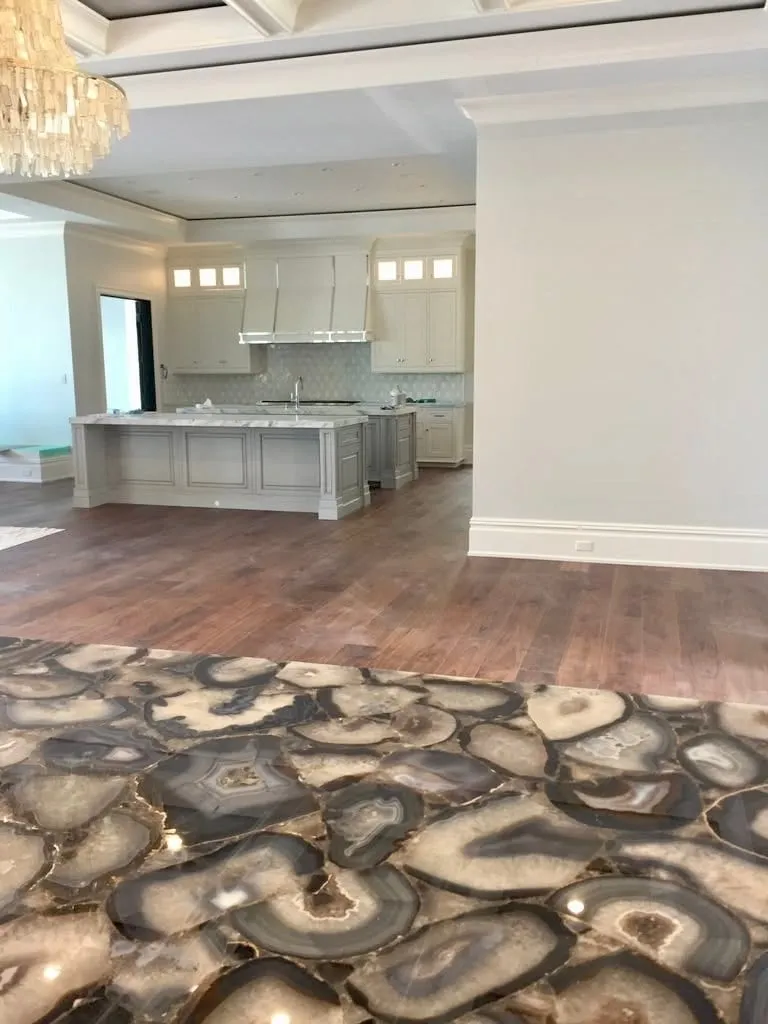 Kitchen with painted cabinets, an island, and wood floors, with an agate stone counter in front