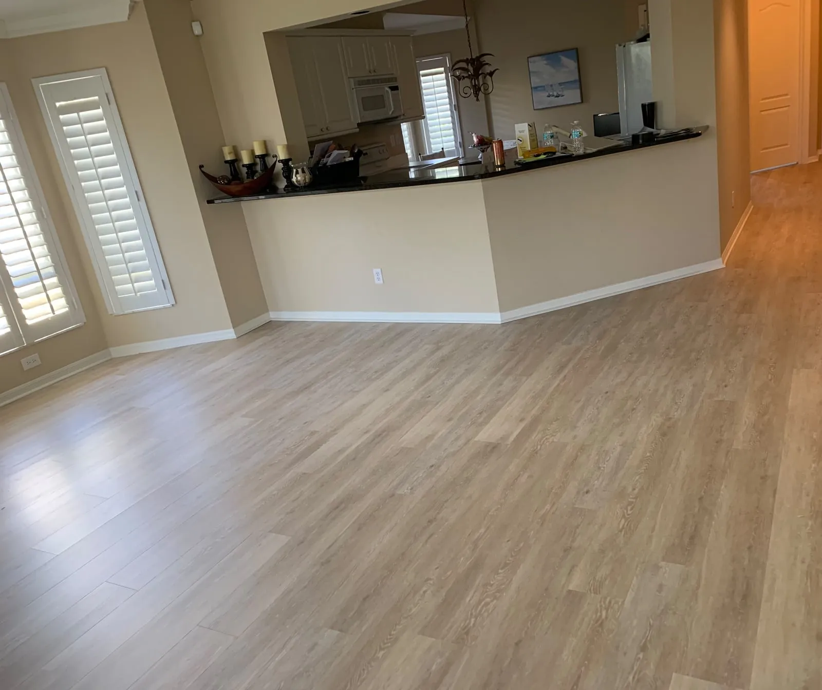 Light hardwood floor through a living room and kitchen
